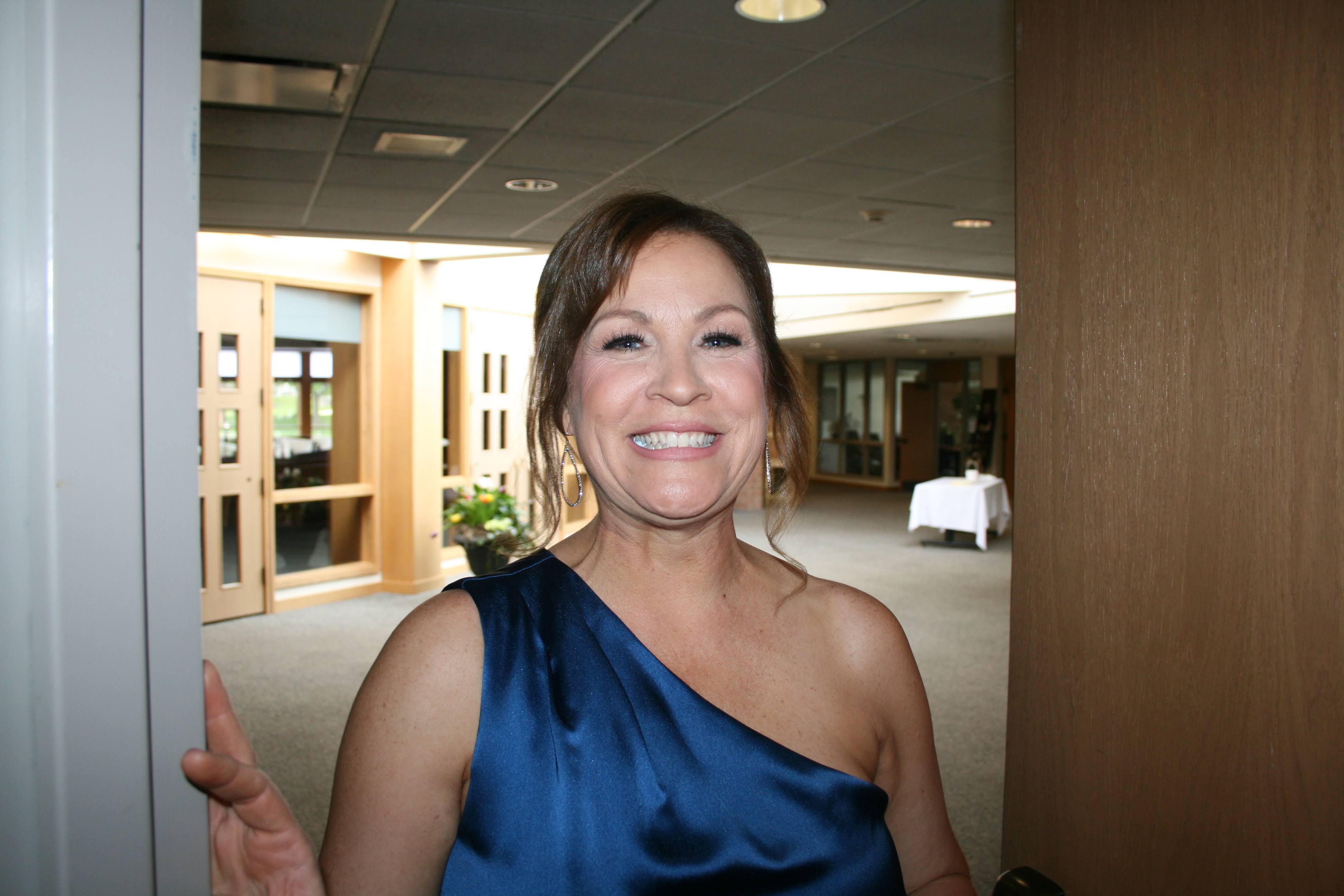 Jen smiling in a navy blue dress.